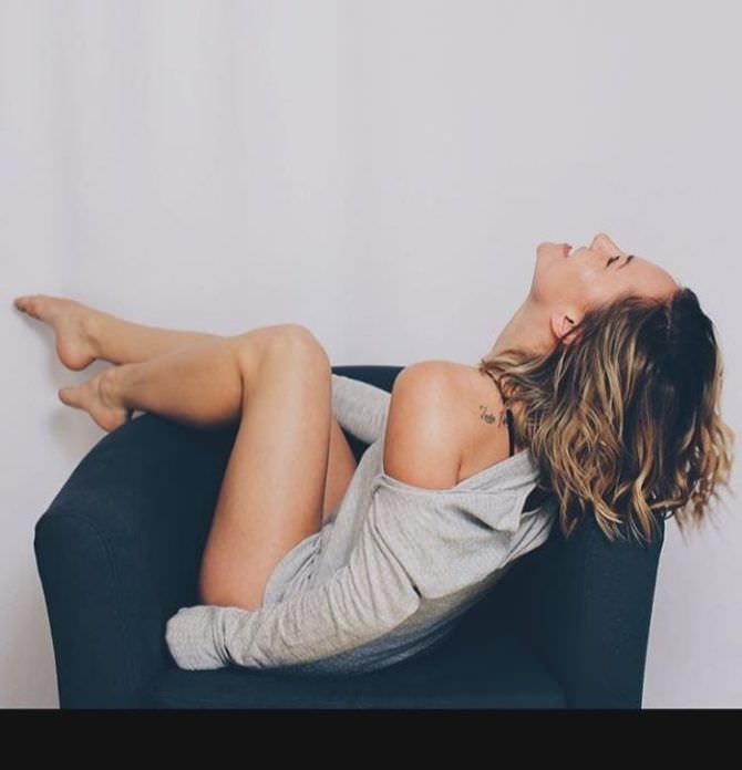 Бриана Эвиган фотография в серой кофте на кресле